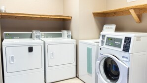 A laundry area with two front-loading washing machines and a top-loading dryer. - Premium Inn and Suites (Killeen)