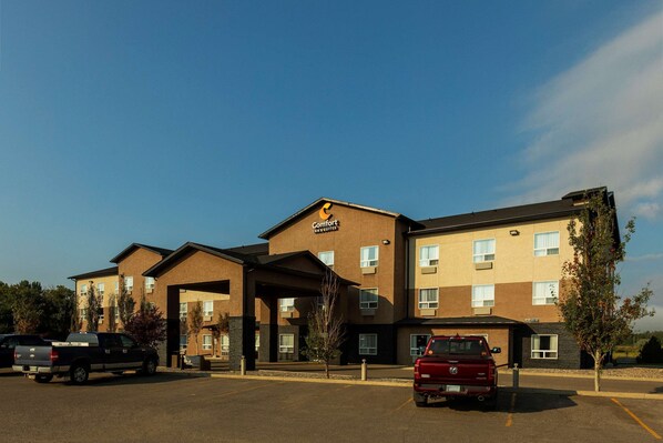 Een Comfort Inn met een gebouw van twee verdiepingen, een overdekte ingang en een parkeerplaats met meerdere voertuigen.
