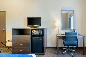 A hotel room with a bed, a desk with a computer, a microwave, and a refrigerator. - Comfort Inn & Suites (Virden)