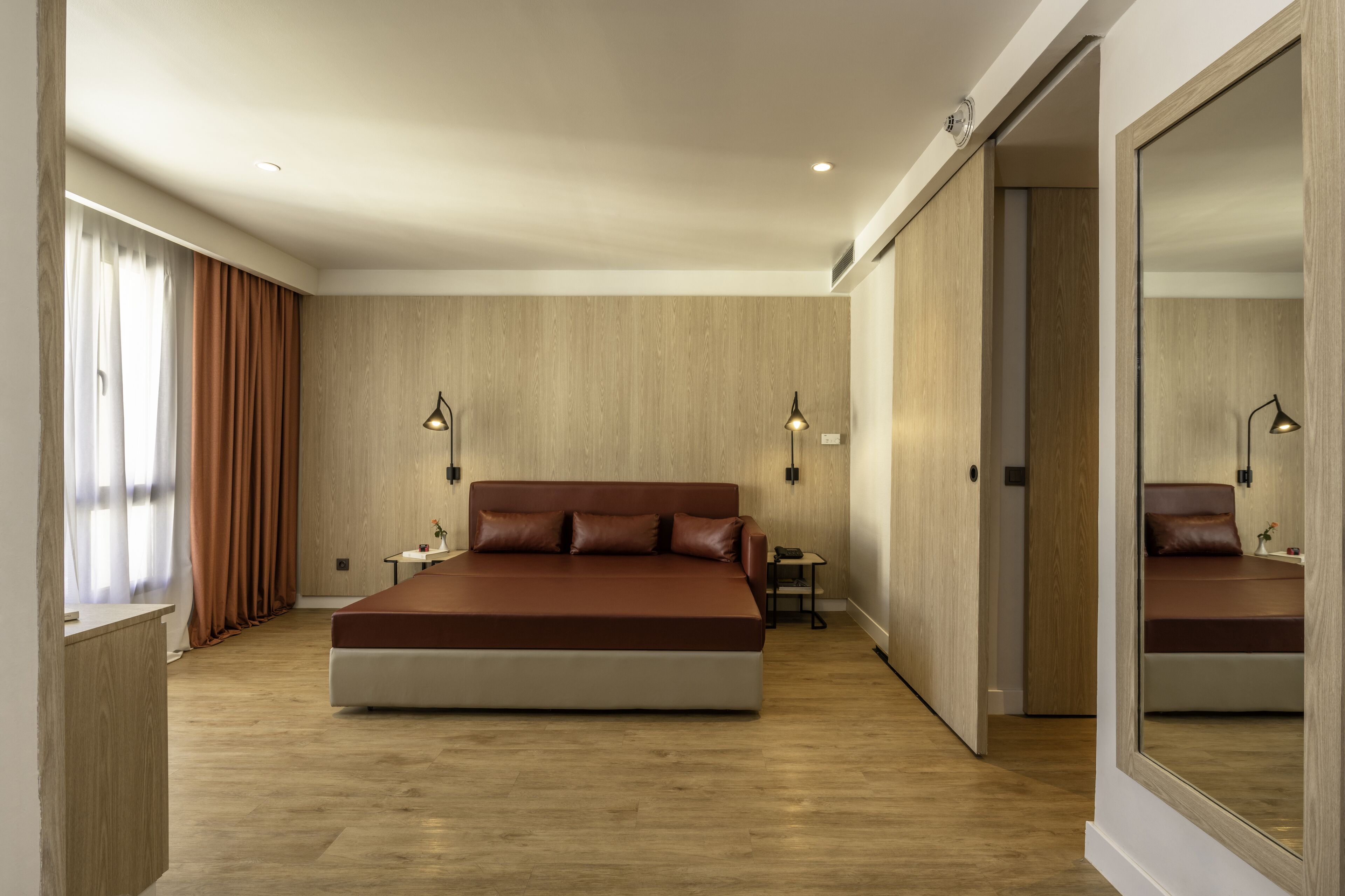 Un dormitorio moderno con una cama grande, paredes de madera y un espejo.