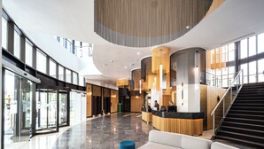 A spacious lobby with a reception desk, seating area, and a staircase. - Barceló Fès Medina (Fes)