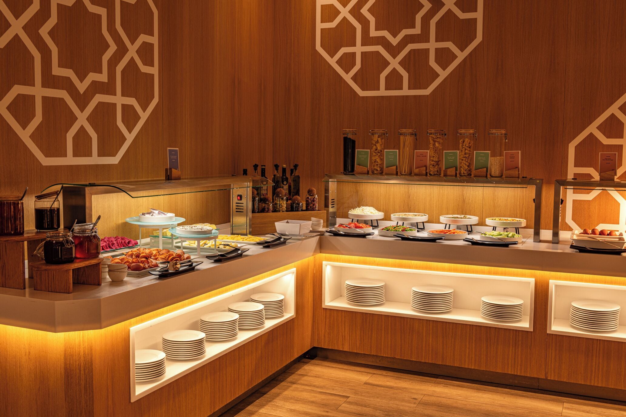 A buffet area with various food stations and a wooden interior design.