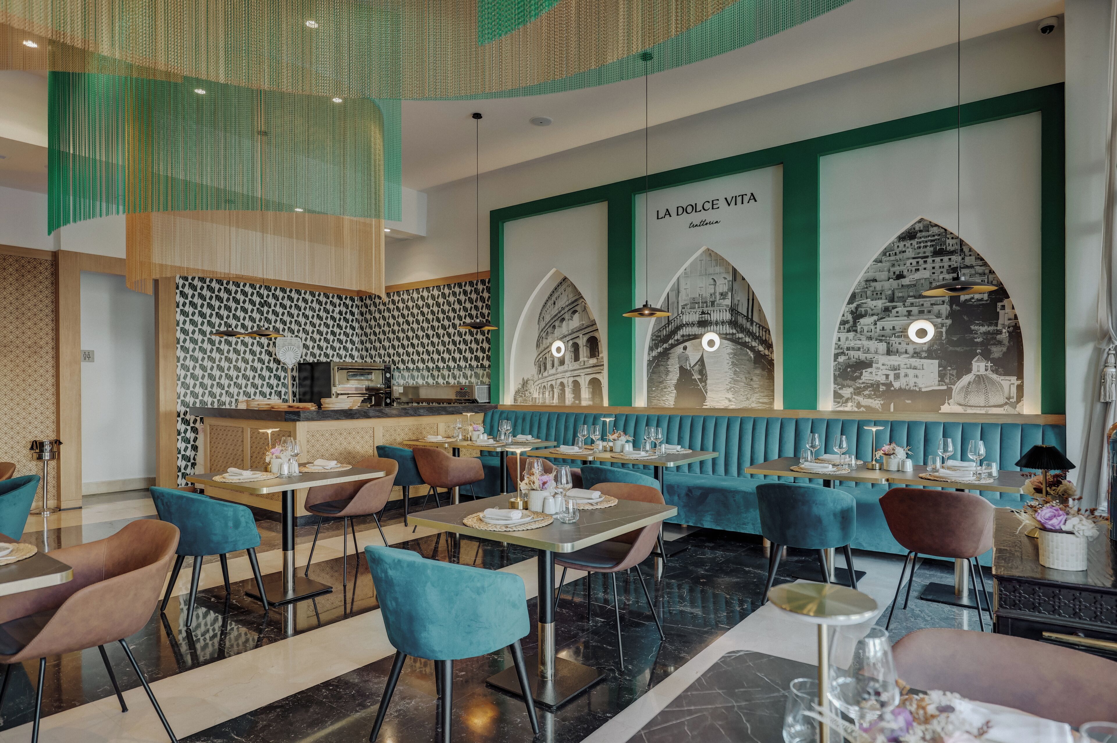 A modern restaurant interior with teal and brown seating, a bar area, and decorative wall art.