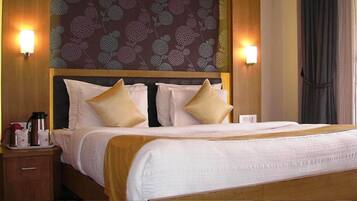 A hotel room with a large bed, two bedside tables, and a patterned wallpaper.