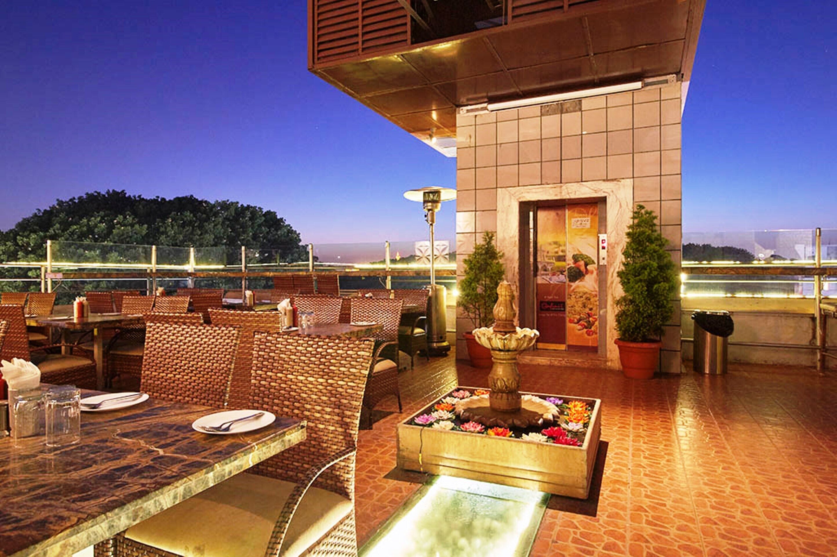 Un área de comedor al aire libre con muebles de mimbre y un arreglo floral.