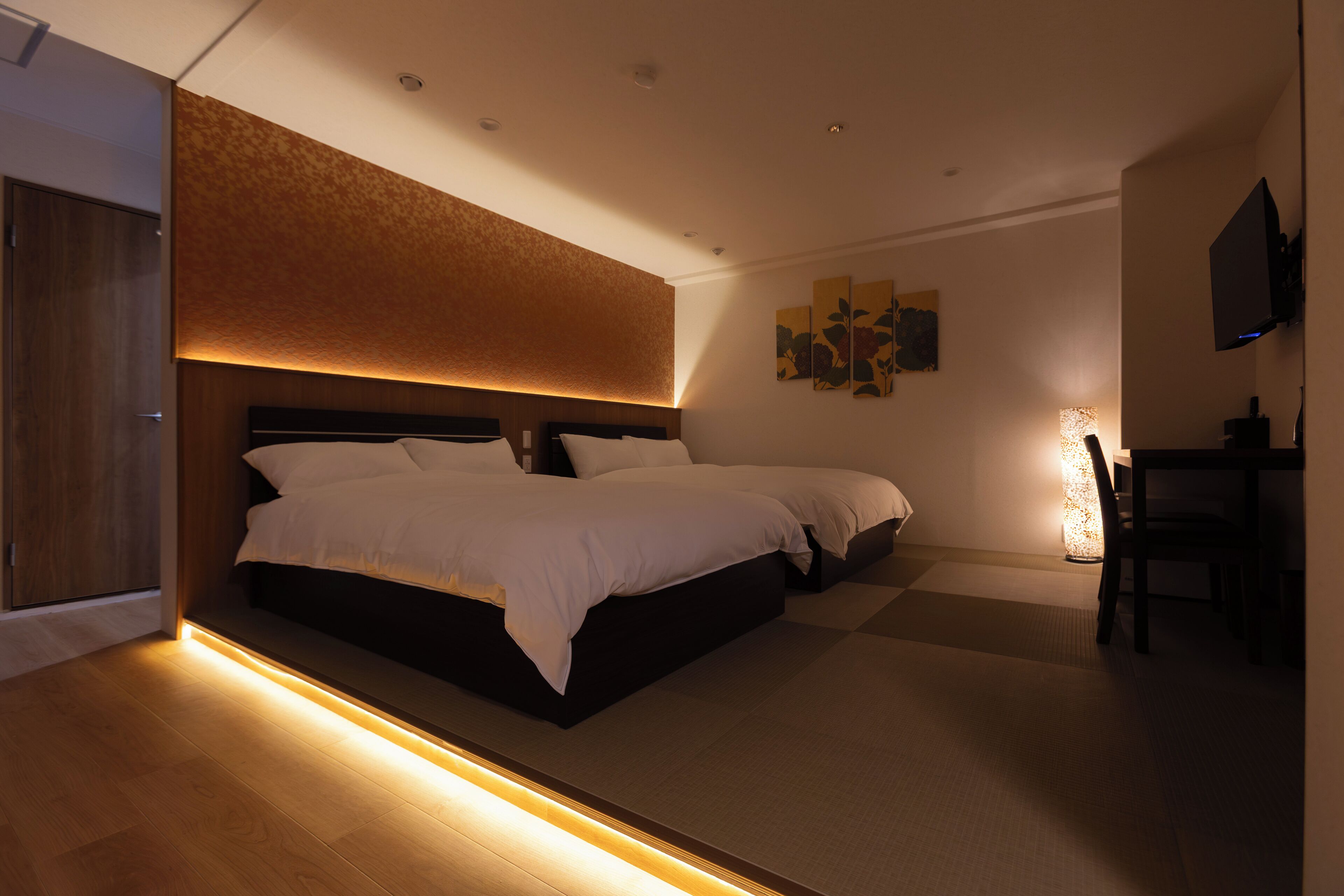 Una habitación de hotel moderna con una cama grande, un escritorio y un televisor.
