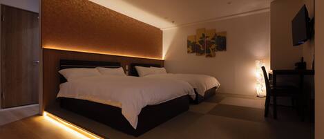 Una habitación de hotel moderna con una cama grande, un escritorio y un televisor.