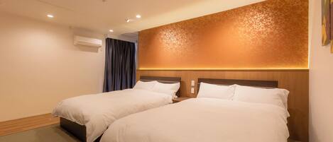 Ein Hotelzimmer mit zwei Betten, einem Holzkopfteil, einer Klimaanlage und einer Wand mit Muster.