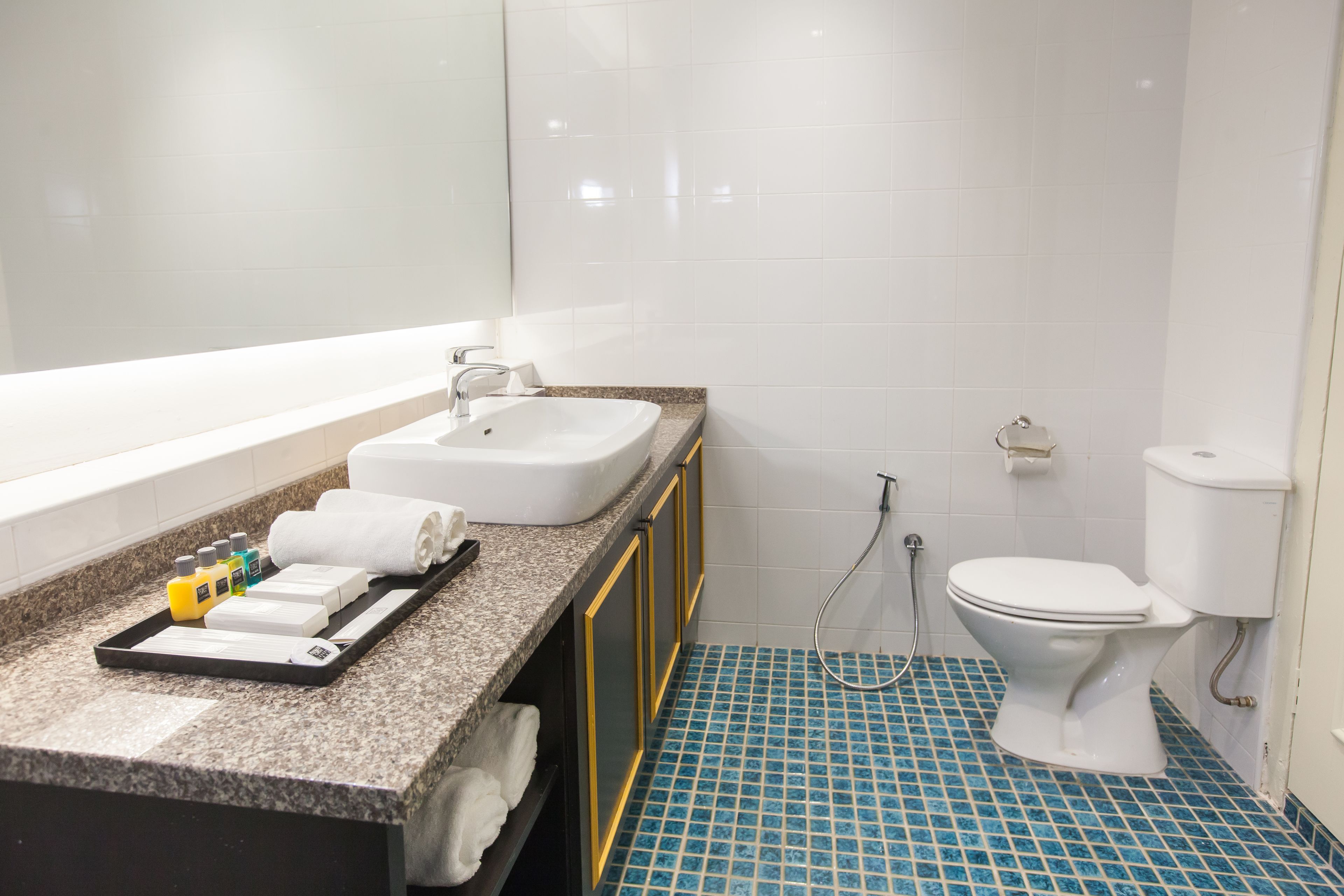 A bathroom with a sink, toilet, and shower.