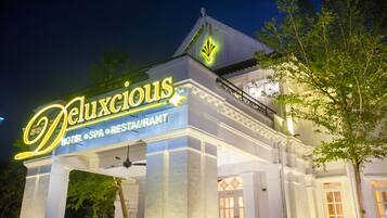 A hotel named 'Deluxious' with a sign indicating it is a hotel, spa, and restaurant.