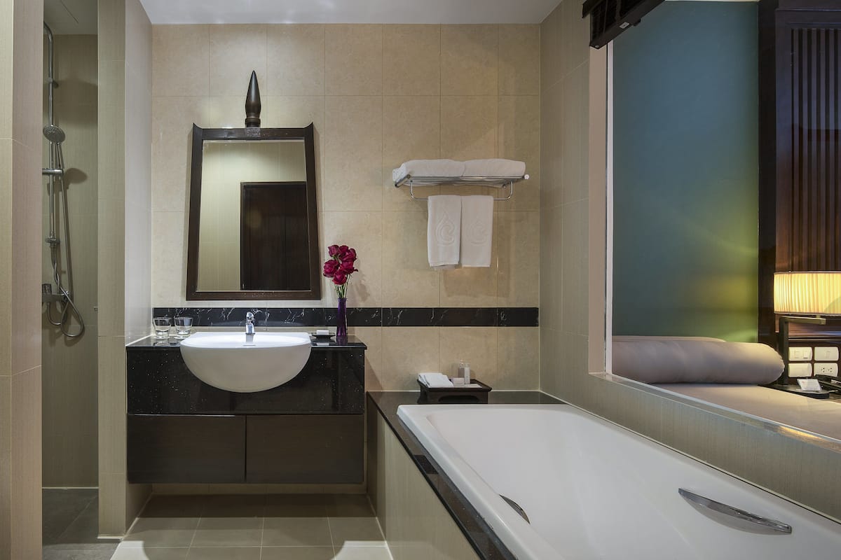 family suite, 1 king bed, pool view | bathroom | combined shower/bathtub, deep-soaking bathtub, rainfall showerhead