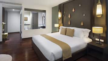 Quarto de hotel com uma cama grande, abajures, mesa de cabeceira, espelho e piso de madeira.