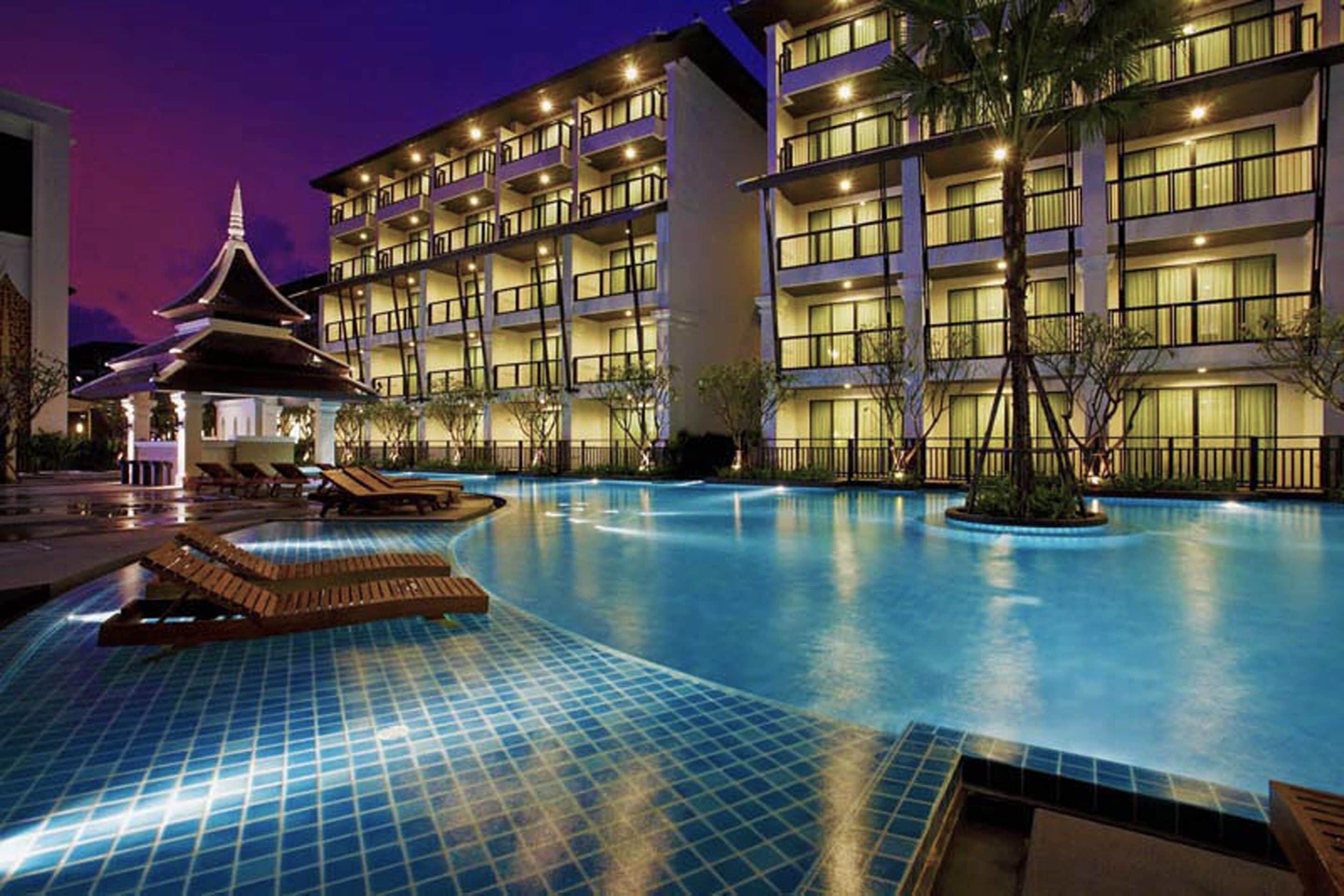 Un hôtel doté d’une grande piscine, d’une structure de style pagode et de nombreux balcons.