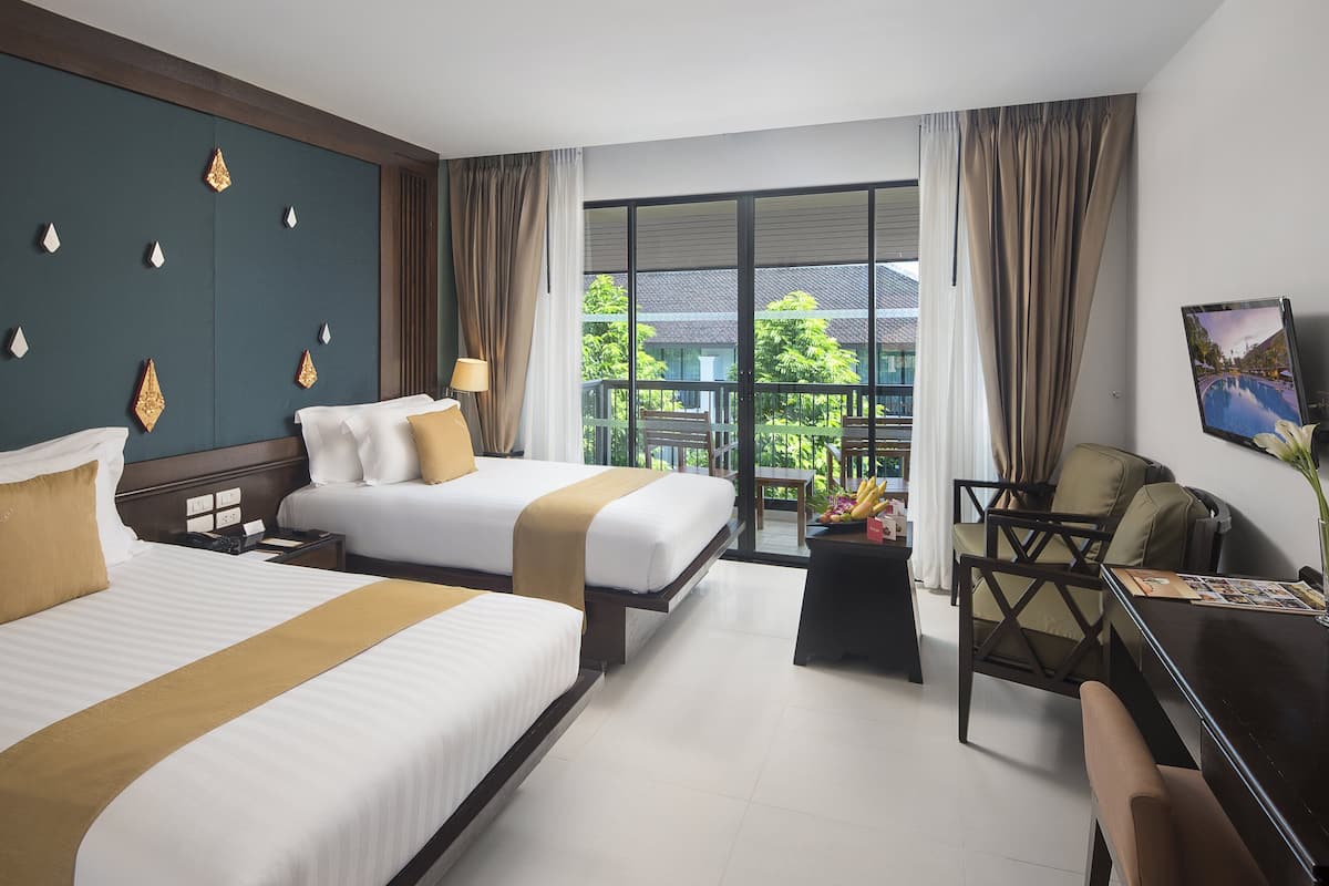 Une chambre d’hôtel avec deux lits, un bureau, une chaise et un balcon avec vue.