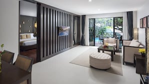 A modern hotel room with a bed, a TV, a dining area with a table and chairs, a sofa, and a balcony with a pool. - Centara Anda Dhevi Resort and Spa Krabi (Krabi)