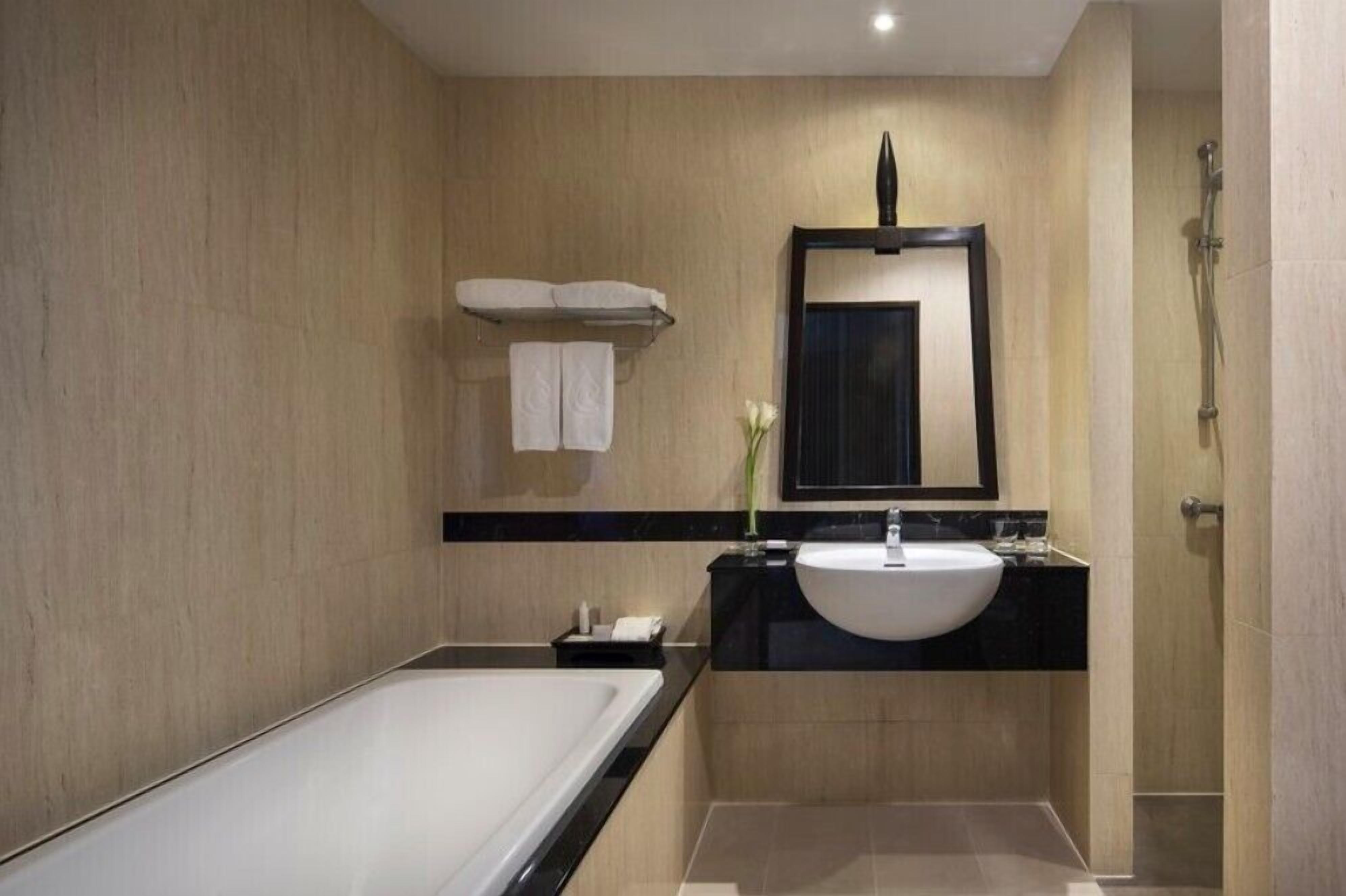 Un baño moderno con bañera, lavamanos y ducha.