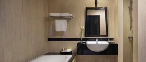 A modern bathroom with a bathtub, a sink, and a shower.
