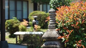 Un edificio tradizionale giapponese con una lanterna in pietra e un giardino curato.