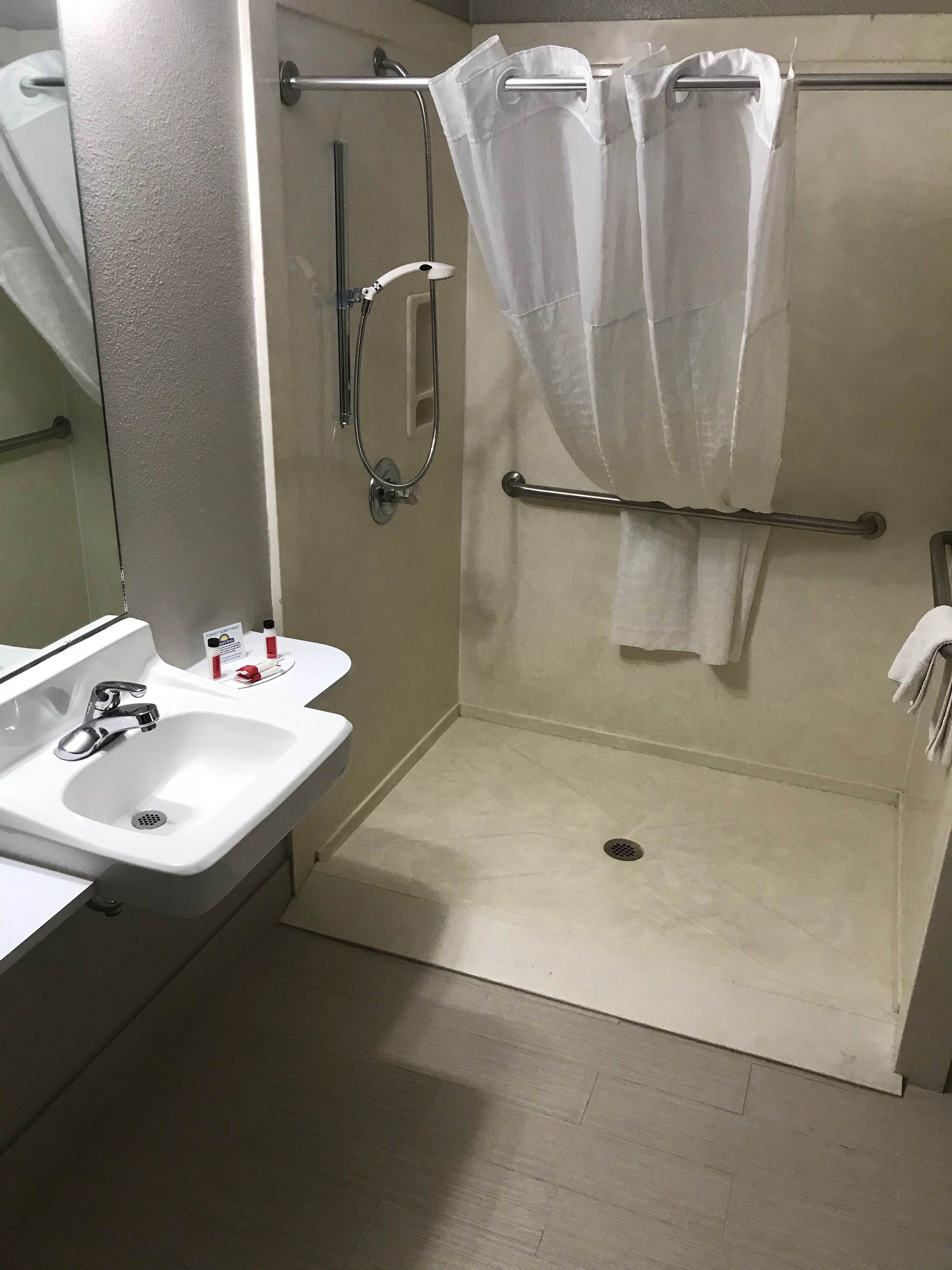 A bathroom with a white sink, a shower with a glass door, and a towel rack.