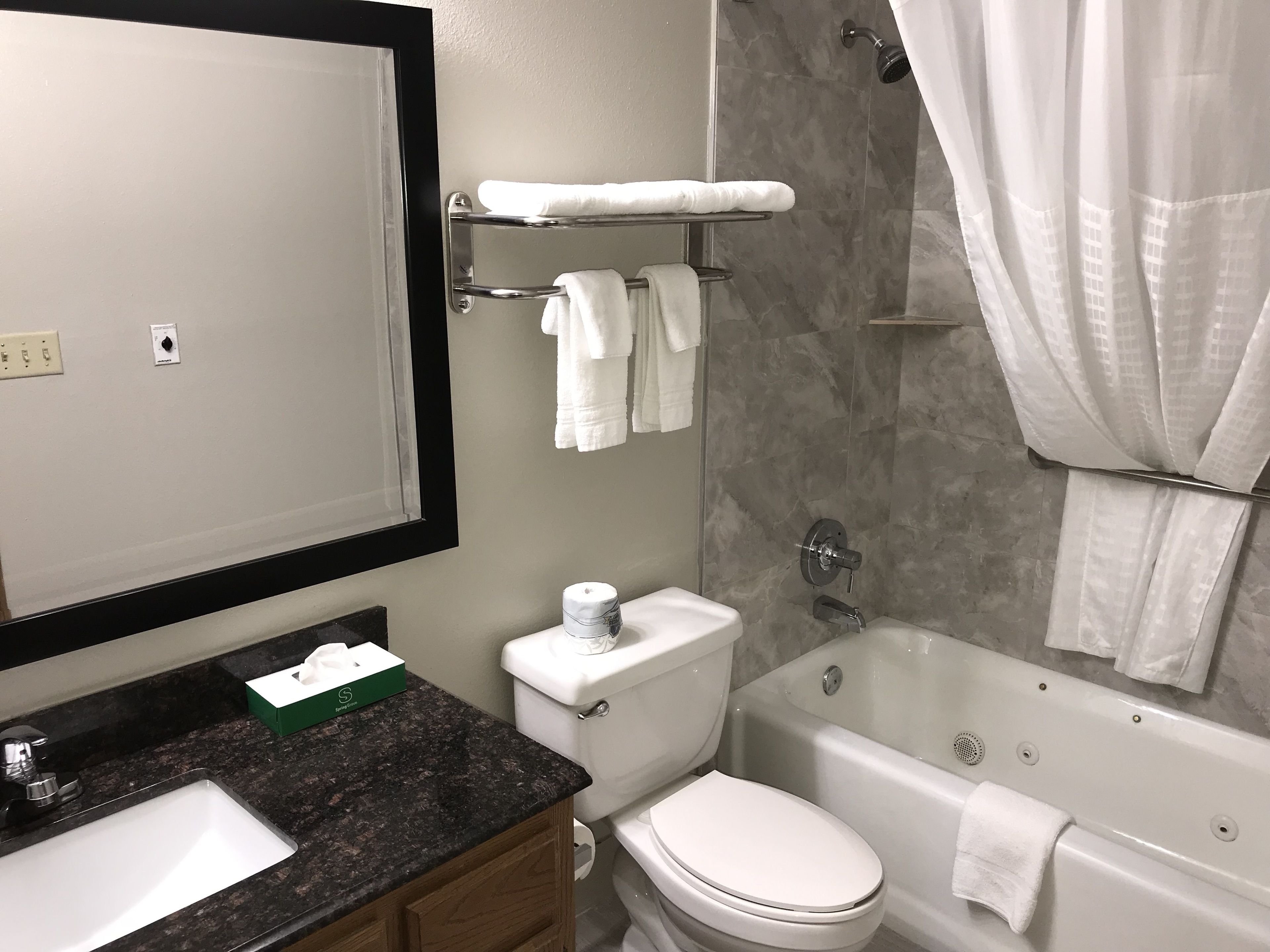 A modern bathroom with a sink, toilet, bathtub, and a towel rack.