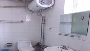 Une petite salle de bain avec des toilettes, un lavabo et un miroir.