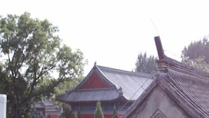 Un bâtiment traditionnel avec un mur rouge et un toit recouvert de tuiles.