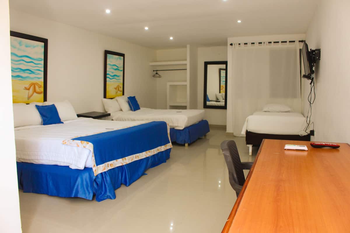 Habitación de hotel con dos camas, una mesa de madera y un televisor.