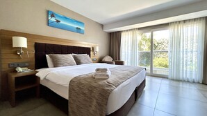A hotel room with a large bed, a nightstand with a phone, a painting on the wall, and a view through the window. - Marina Boutique Fethiye - Boutique Class (Fethiye)
