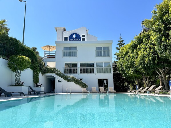 Una piscina al aire libre, tumbonas