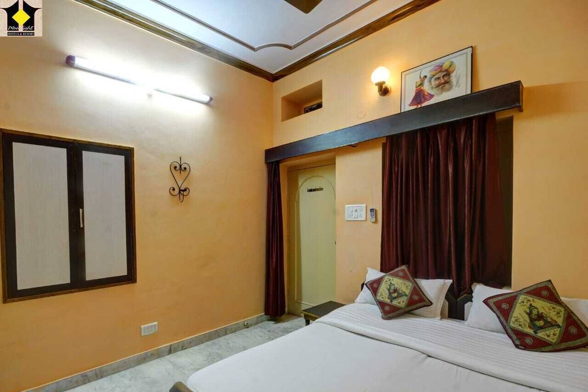 Een hotelkamer met een bed, een kledingkast, een deur en een lamp aan de muur.