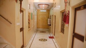 Ein Hotelgang mit Marmorboden, einer zentralen Klimaanlage und einer Tür mit der Nummer 102.