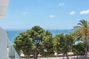 A coastal view with a clear sky, a beach, and sailboats. - Palia Tropico (Calvia)