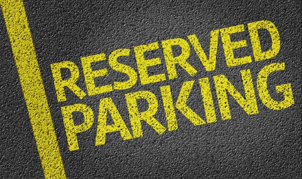 A close-up of a "RESERVED PARKING" sign painted on a textured surface. - Ibis budget Charleroi Airport (Fleurus)