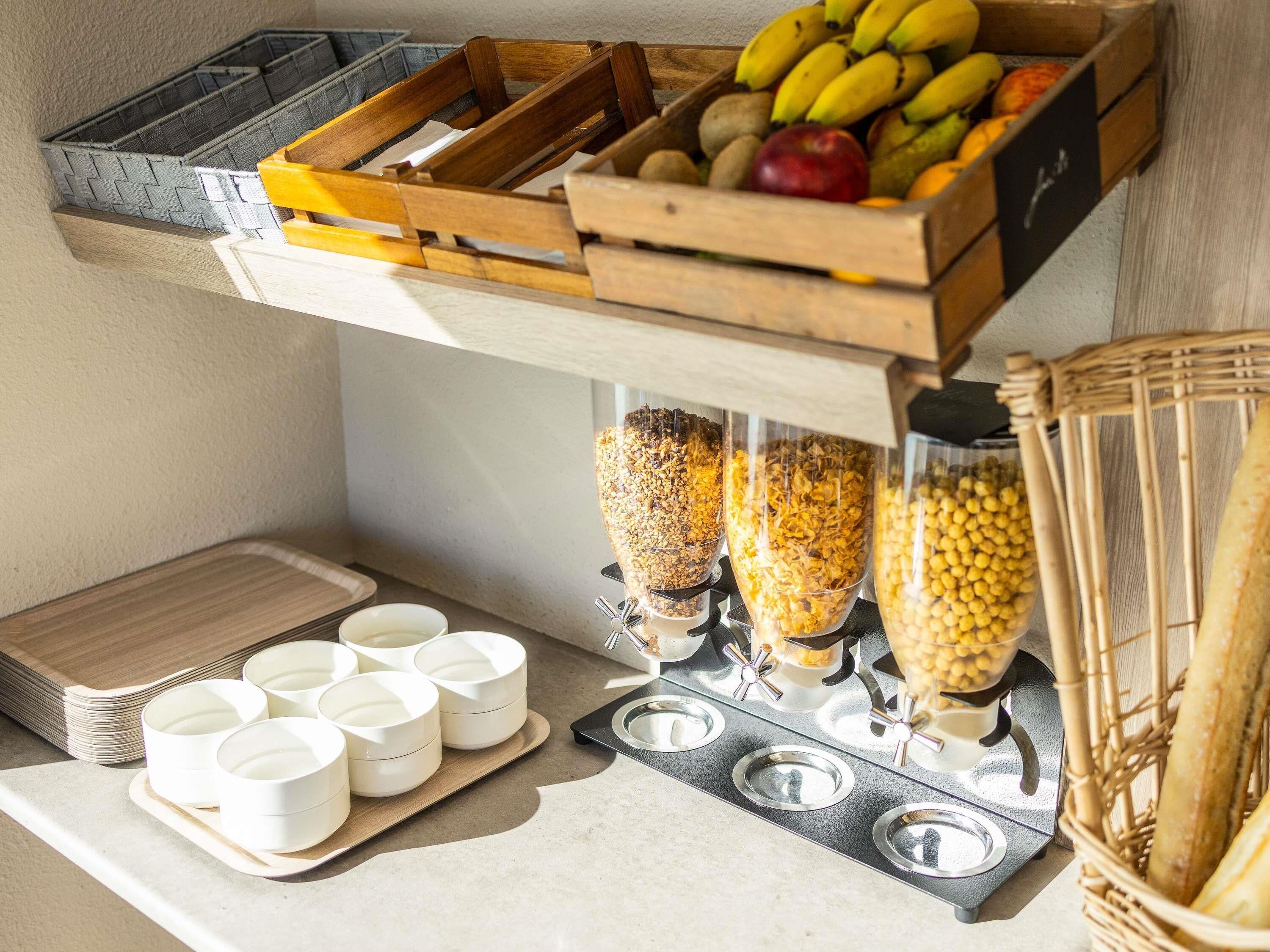 Una cocina con zona de preparación de alimentos, una cesta de frutas y recipientes de almacenamiento.