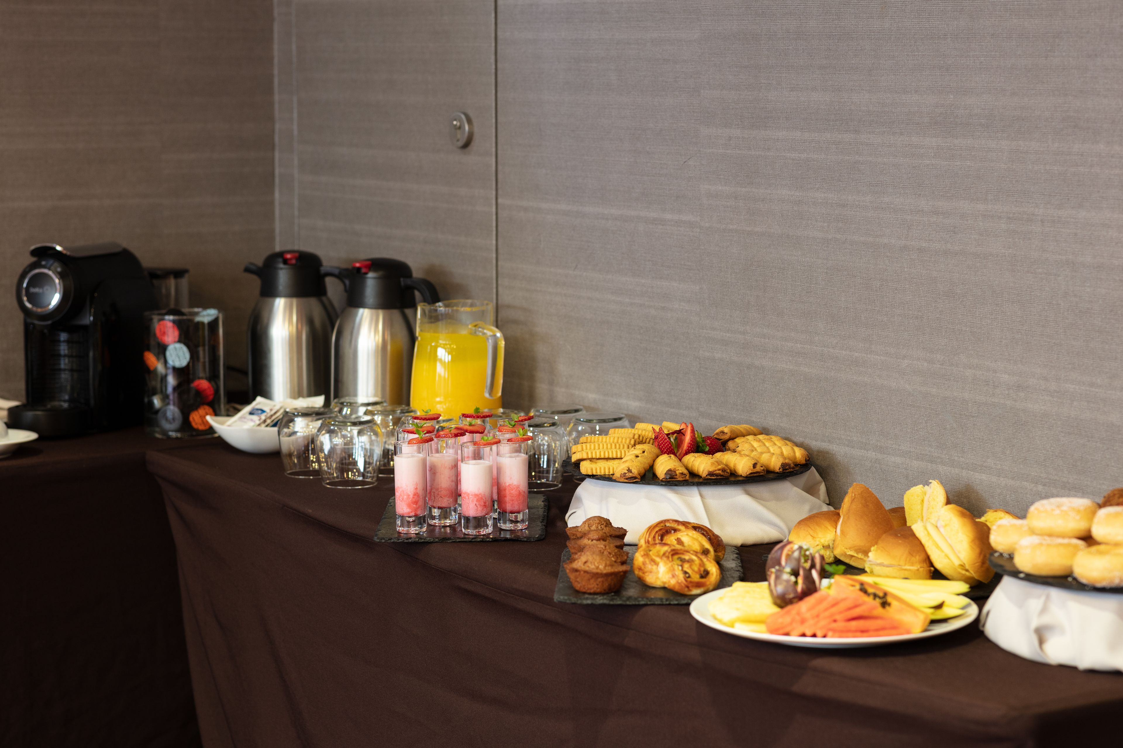 Ein reichhaltiges Frühstücksbuffet mit Speisen, Getränken und Kaffeeautomaten.