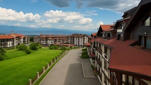 Un hôtel à étages, doté d’une cour intérieure et offrant une vue sur les montagnes en arrière-plan.
