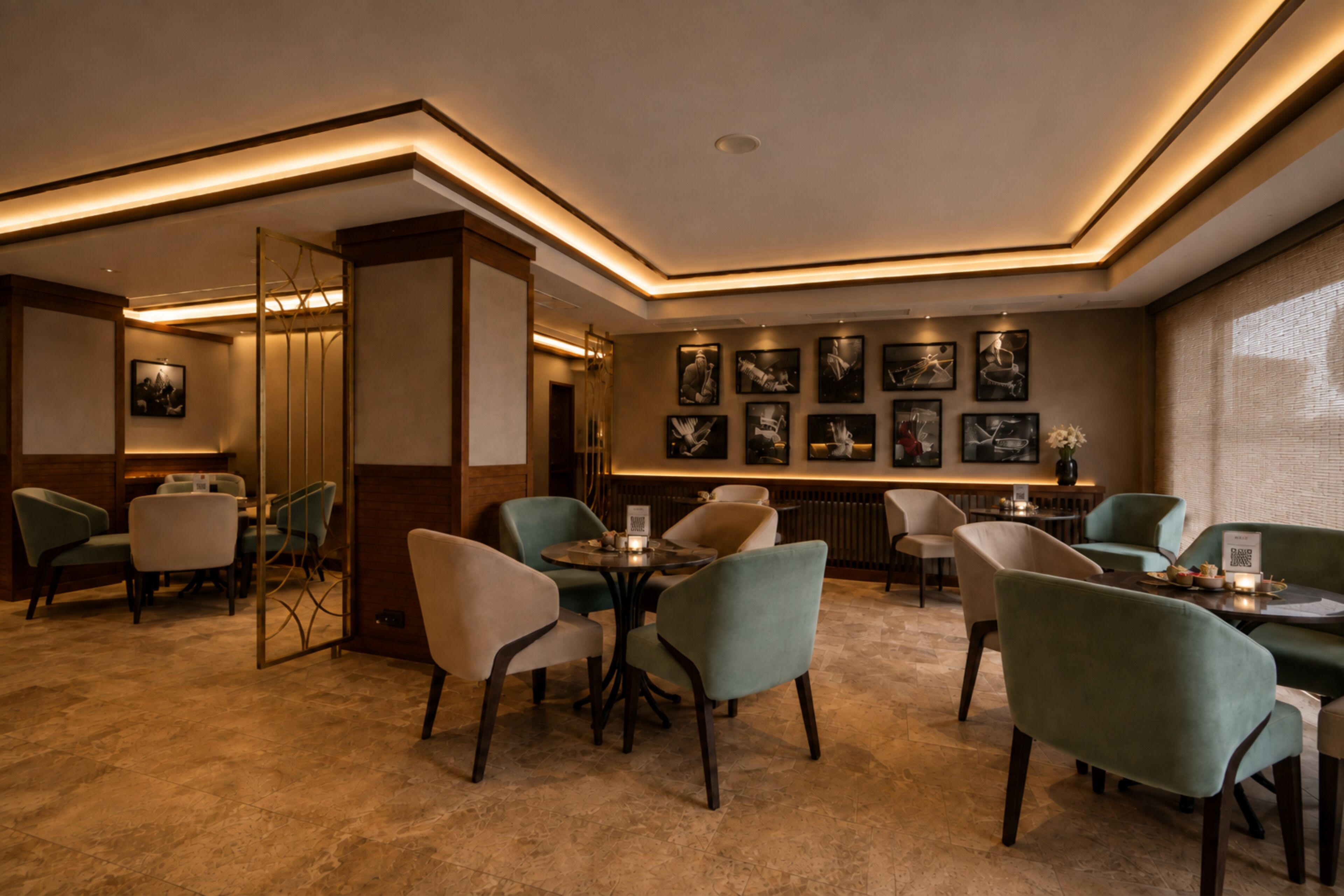 A modern interior with a mix of seating arrangements, including tables and chairs, and a wall adorned with framed artwork.