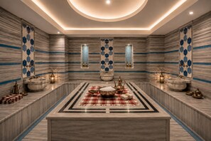 A luxurious bathroom with a central marble sink, two wall-mounted bidets, and a decorative rug.