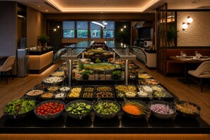 Una mesa de buffet con diversos alimentos y vista al interior del restaurante.