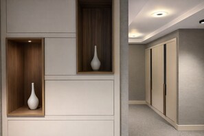 Un pasillo con estanterías empotradas, cada una con un jarrón blanco.