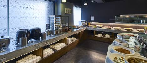 A buffet area with various food items and utensils.