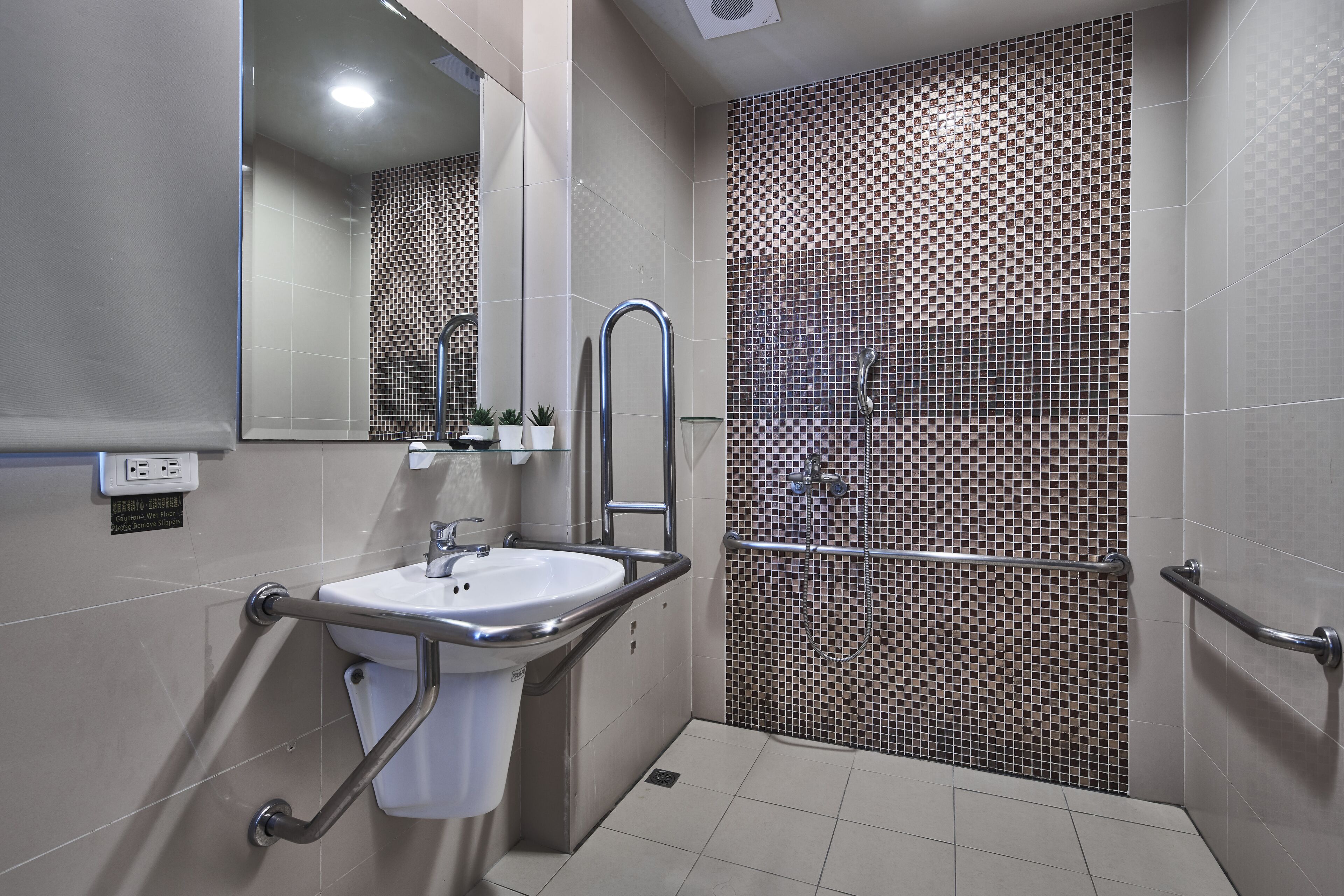 Un baño moderno con lavamanos, espejo y zona de ducha.