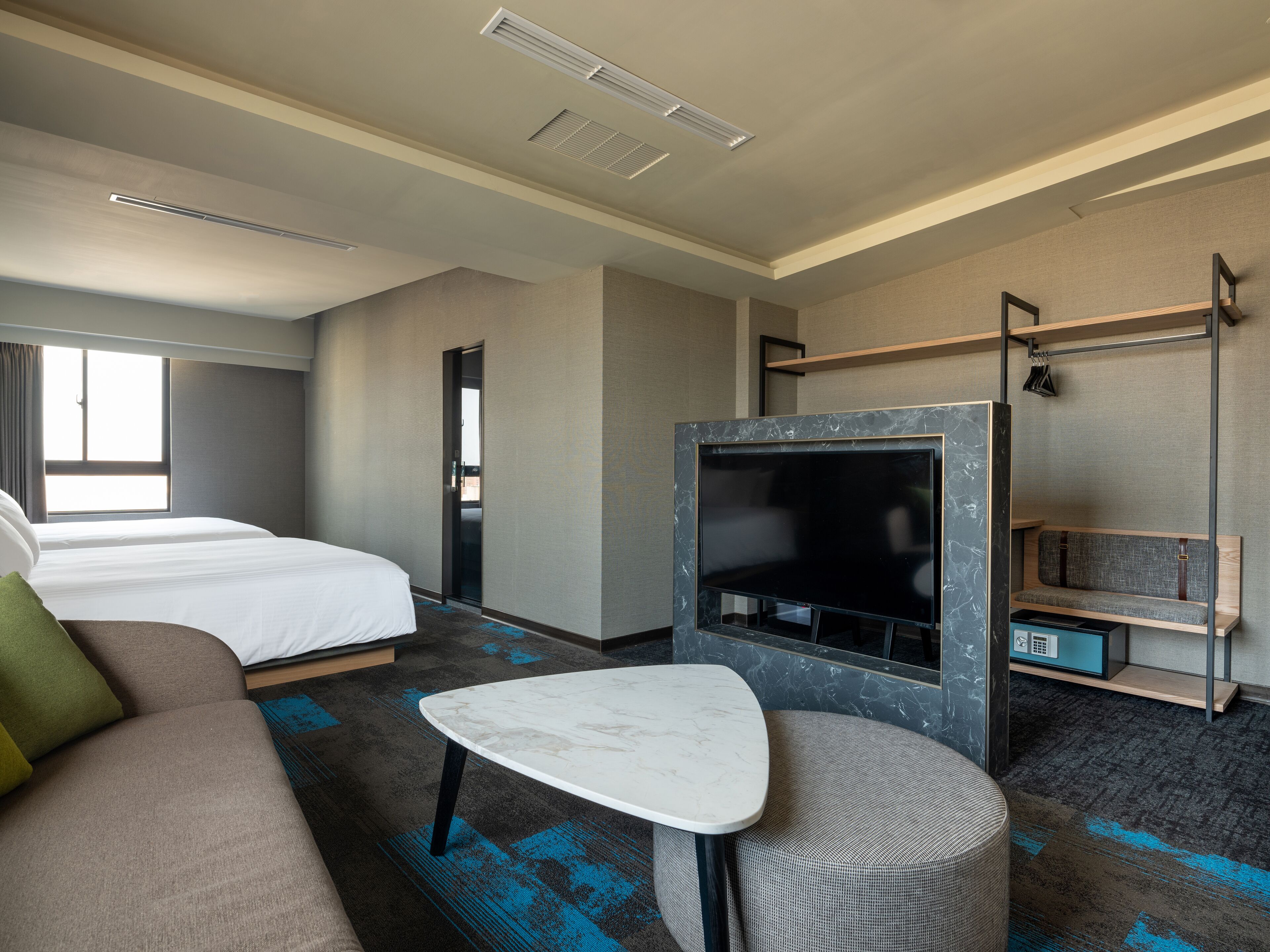 Habitación de hotel con cama, televisión, una mesita y zona de estar.