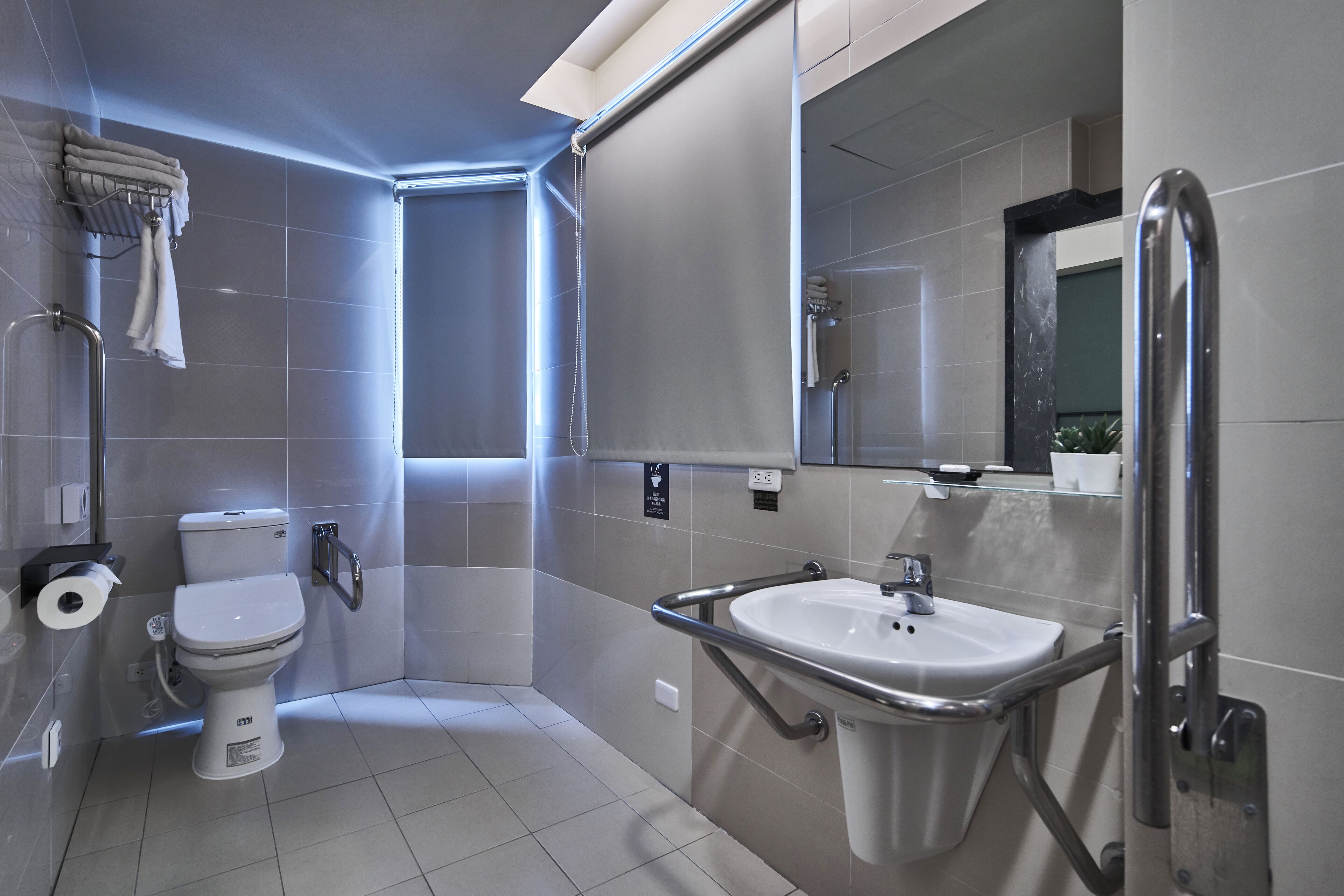 Et moderne badeværelse med toilet, vask og brusebad.