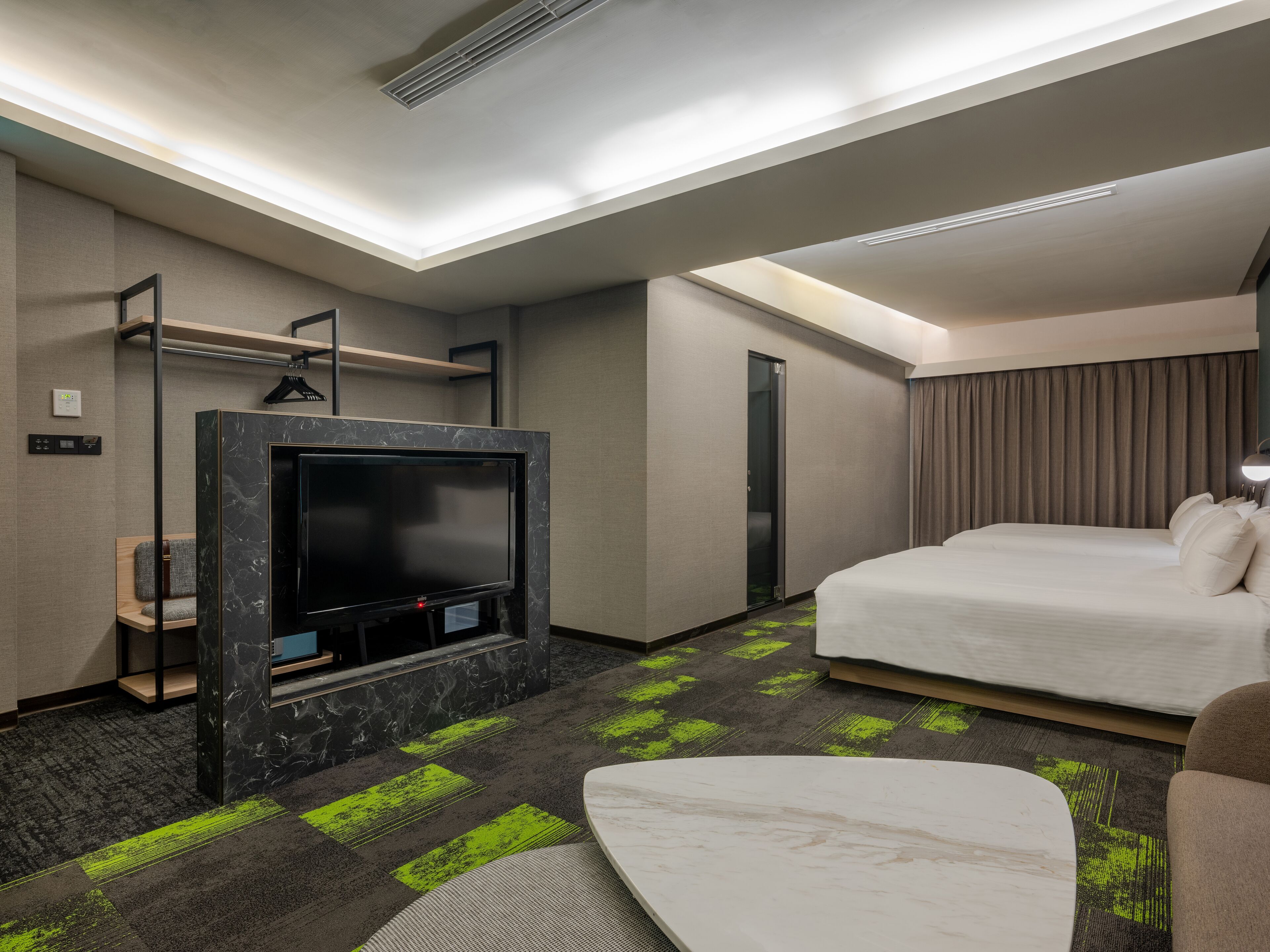 A hotel room with a bed, a TV, a desk, and a shower.