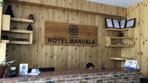 A wooden reception desk with a sign reading "HOTEL MANDALA" and a logo indicating it has been established since 1970. - Hotel Mandala (Pokhara)