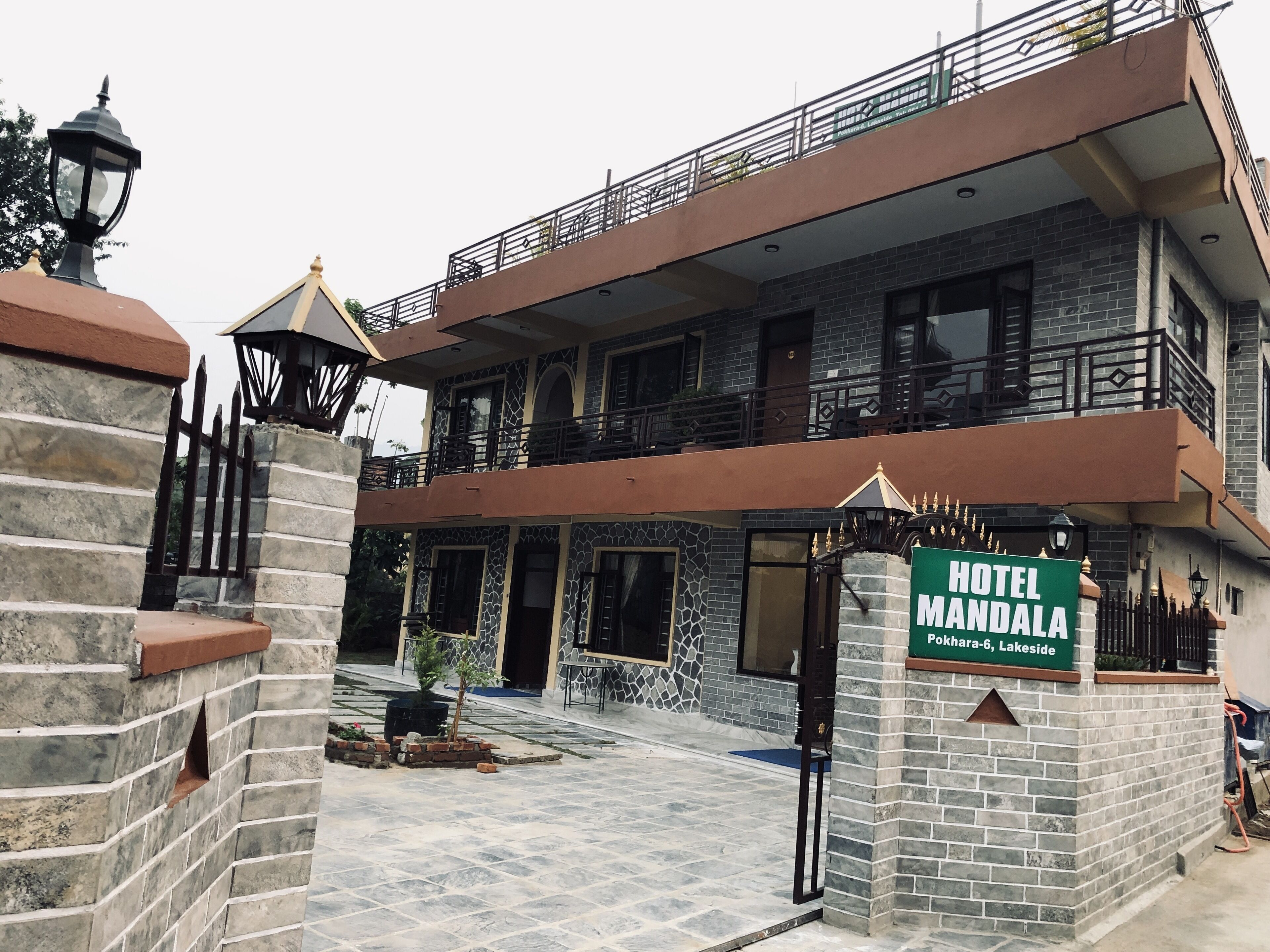 A two-story building with a sign reading "Hotel Mandala Pokhara-6, Lakeside".