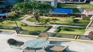 An outdoor patio with a round table and four chairs, surrounded by a low fence. - Hotel Mandala (Pokhara)