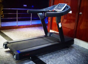 A treadmill with a digital display, placed on a carpeted floor. - Hotel Sohi Residency (New Delhi)
