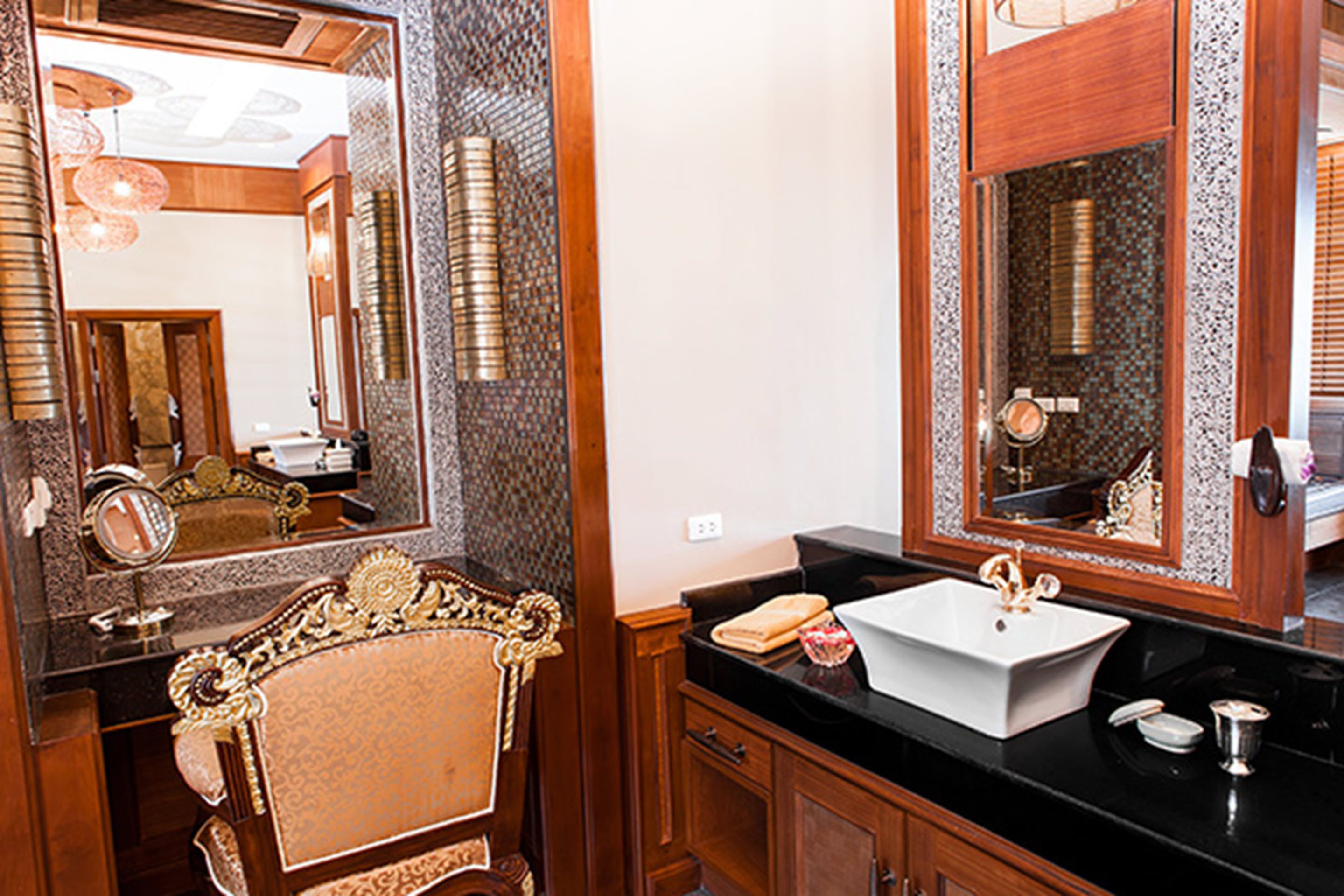 A bathroom with a large mirror, a white sink, and wooden cabinetry.
